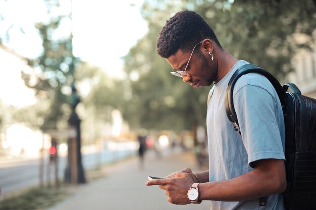 young man in the street uses a smartphone