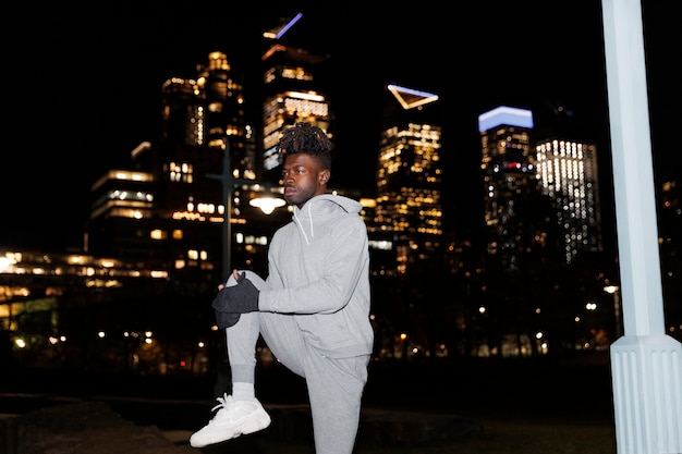 Young man stretching at night in the city