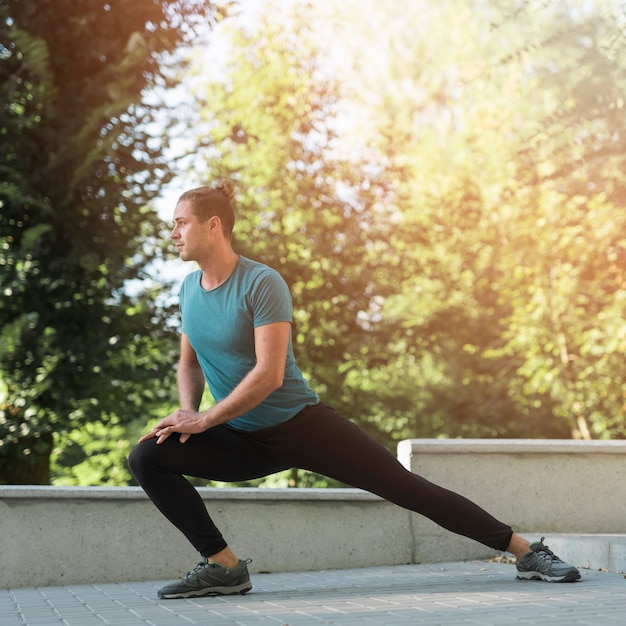 Free photo young man stretching in the park