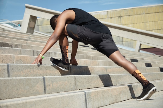 Young man stretching on stairs