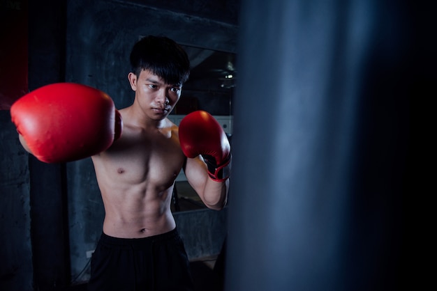 若い男の強いスポーツ男ボクサーはジム、健康的な概念の練習をする