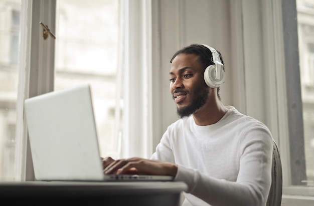 若い男は音楽を聴いてPCで勉強します