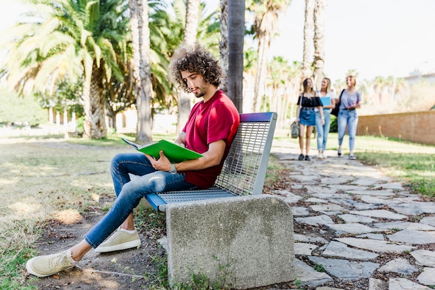 Free photo young man studying on bench