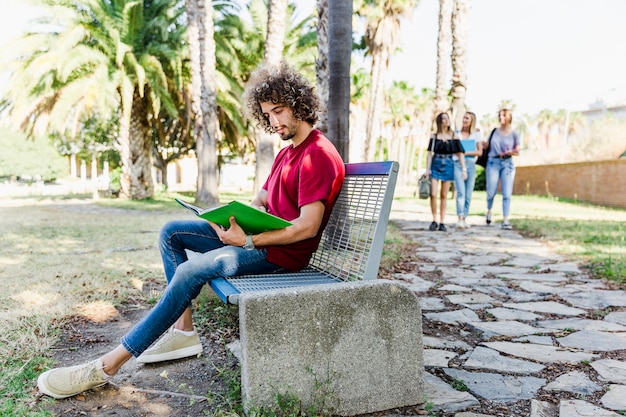 Young man studying on bench 