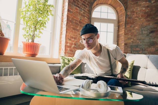 Young man studying at home during online courses or free information by hisself