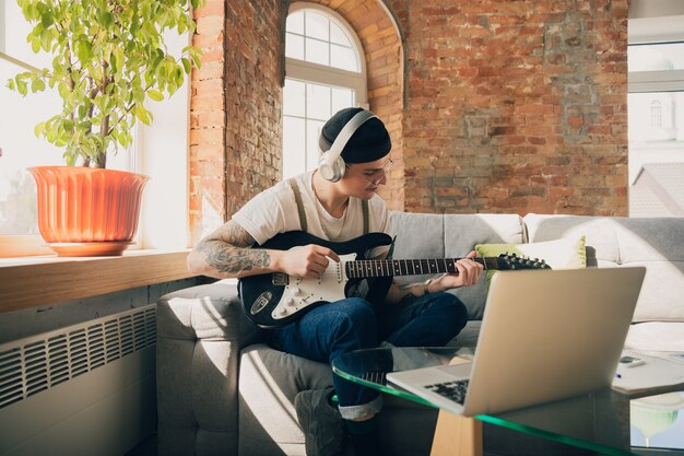 Young man studying at home during online courses or free information by hisself