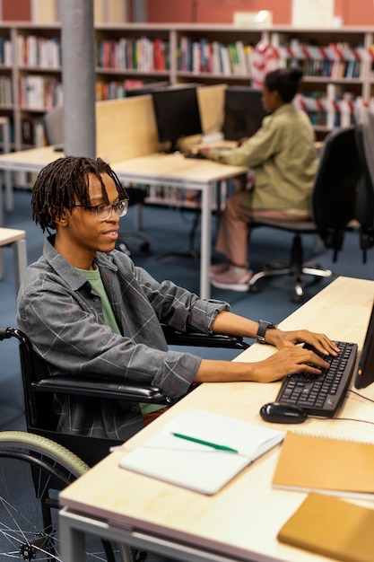 Giovane che studia nella biblioteca dell'università