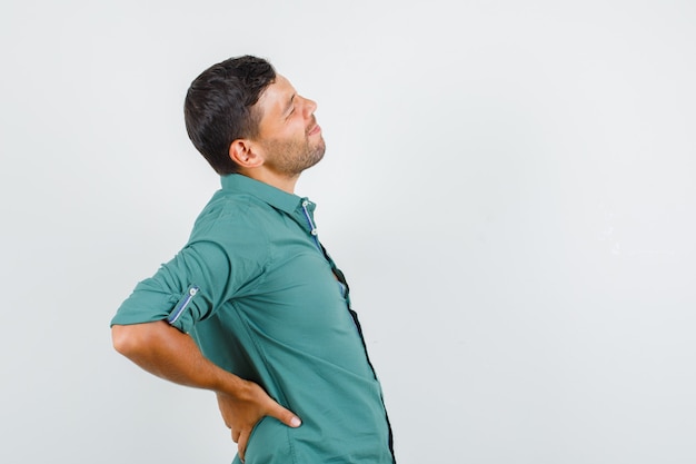 Free photo young man suffering from back pain in shirt.