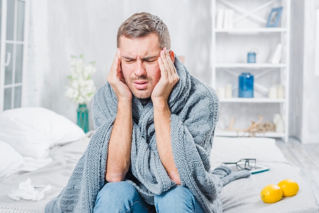 Young man suffering from cold having headache