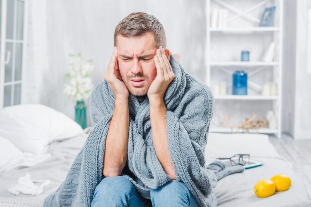 Young man suffering from cold having headache