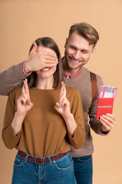 Young man surprising girlfriend with passport and plane tickets for traveling