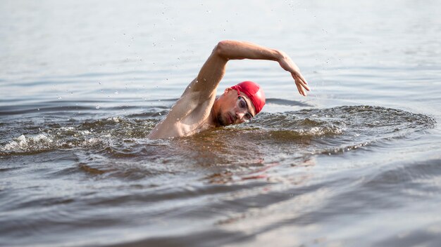 Молодой человек купается в озере