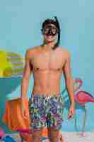 Free photo young man in swimwear wearing swimming mask and smiling