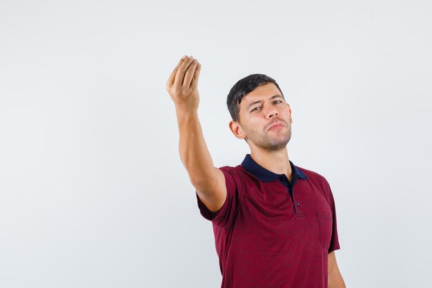 Young man in t-shirt doing italian gesture , front view.