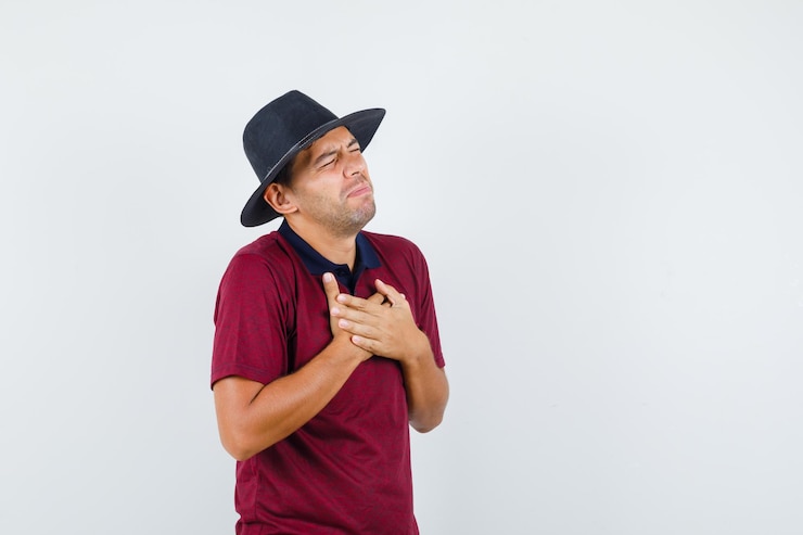 無料Photo tシャツを着た若い男、胸の痛みに苦しんでいる帽子、病気に見える、正面図。