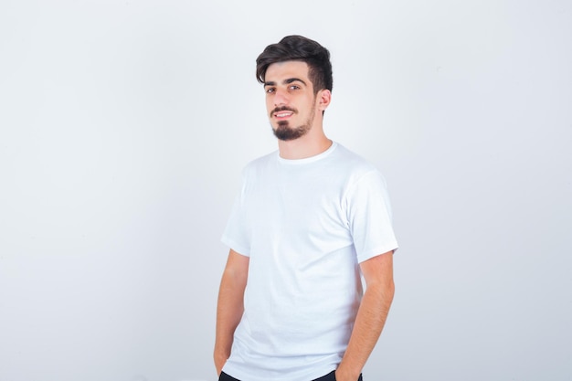 Young man in t-shirt looking at front while standing and looking happy