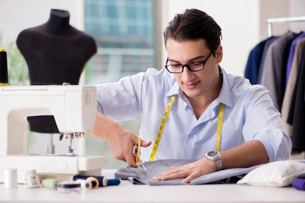 Premium Photo | Young man tailor working on new clothing