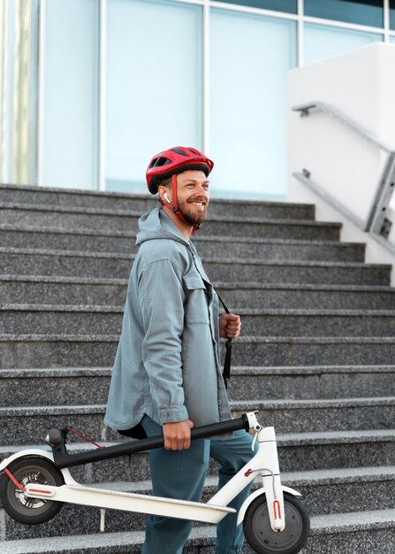 Young man taking a break after riding his scooter outdoors