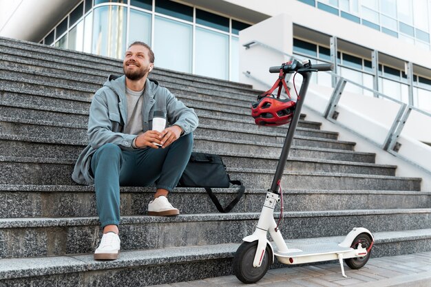 Young man taking a break after riding his scooter