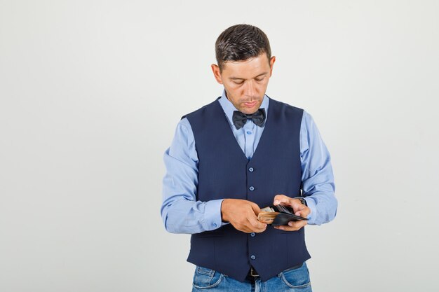 Young man taking money out of wallet in suit