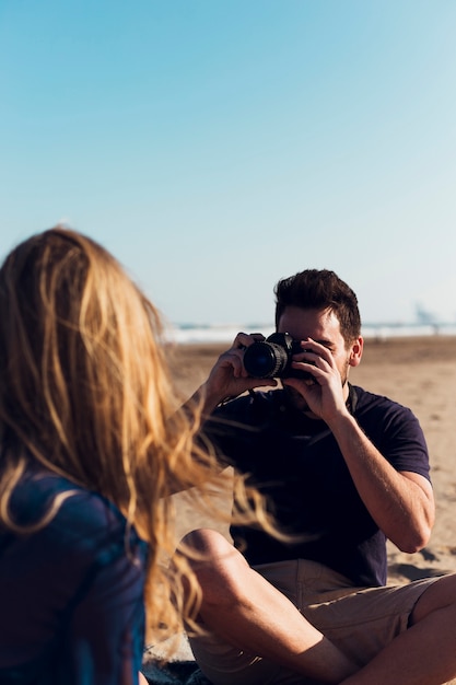 女性の写真を撮っている若い男