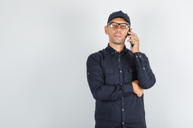 Young man talking on mobile phone in black shirt