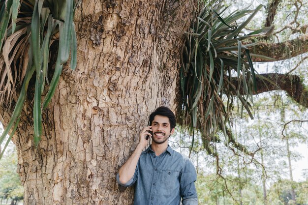 Young man talking on phone in park