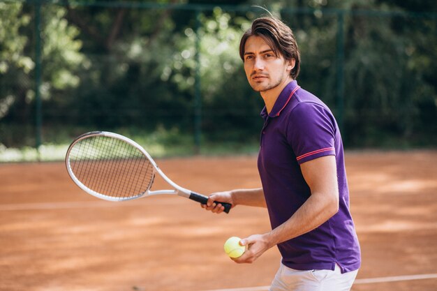 Young man tennis player at the court