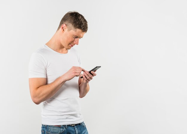 Young man texting on mobile phone isolated on white backdrop