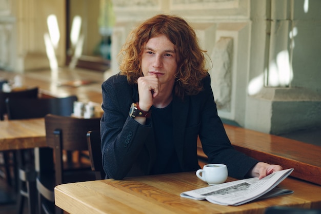 Young man thinking while having coffee