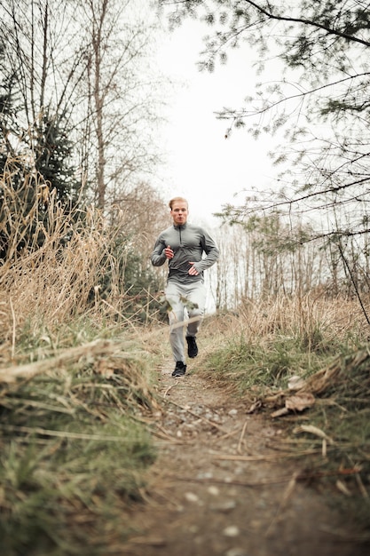 Young man trail running in the forest