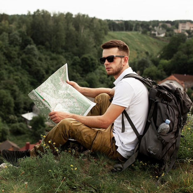 Young man traveling alone reading map