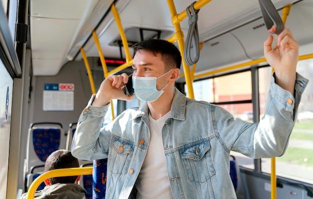 Young man travelling by city bus using smartphone