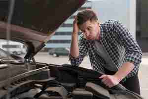 Free photo young man trying to repair car