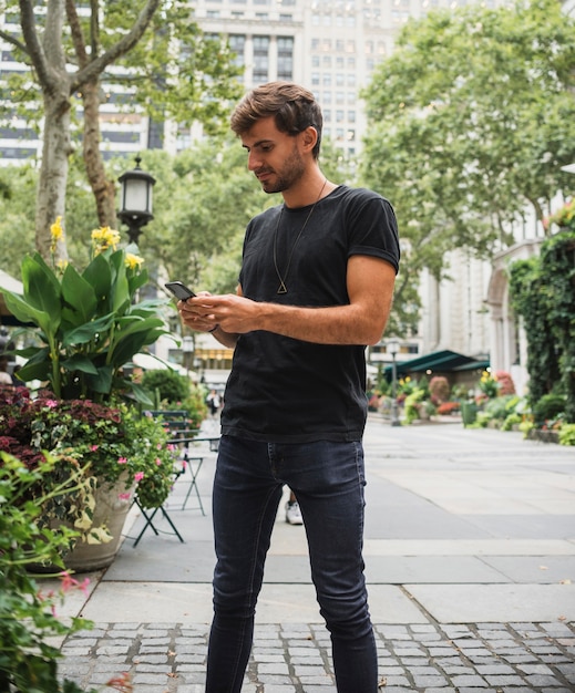 Free photo young man typing on the phone