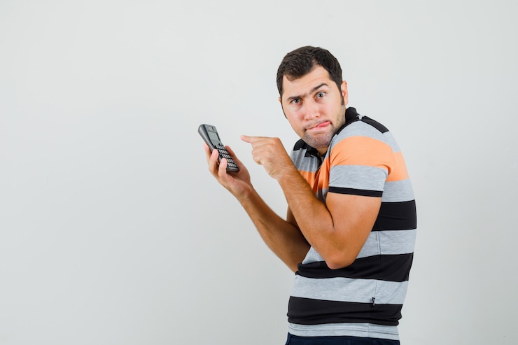 Free Photo young man typing something at phone while looking aside in t-shirt and looking focused .