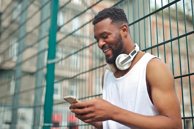 Free photo young man uses a phone in a park