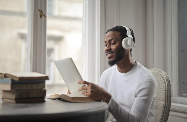 young man uses a tablet at home