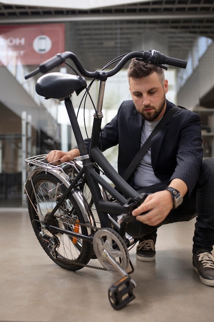 무료 사진 도시에서 접이식 자전거를 사용하는 청년