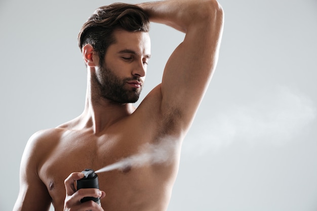 Free photo young man using deodorant