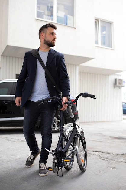 Молодой человек, использующий складной велосипед в городе