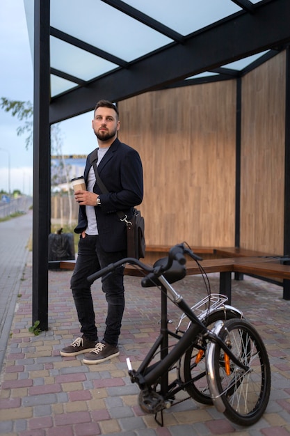 Free photo young man using a folding bike in the city