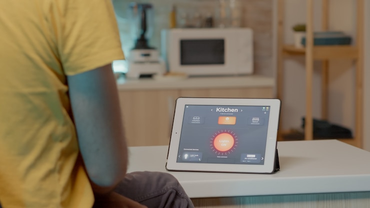 Free Photo young man using smart home application with voice command to turn on the light with digital tablet m...