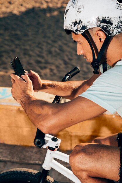 Young man using smart phone on his bike