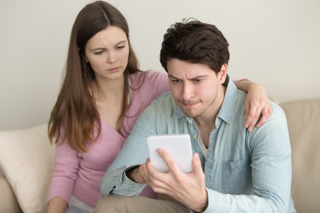 Young man using tablet, having problems