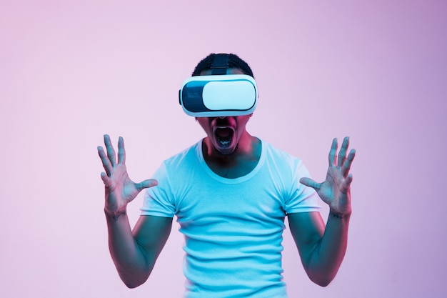 Free photo young man using vr glasses in neon light