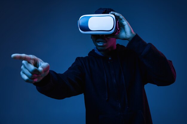 네온 불빛에 VR 안경을 사용하는 젊은 남자