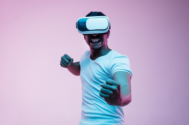 Young man using VR-glasses with neon lights