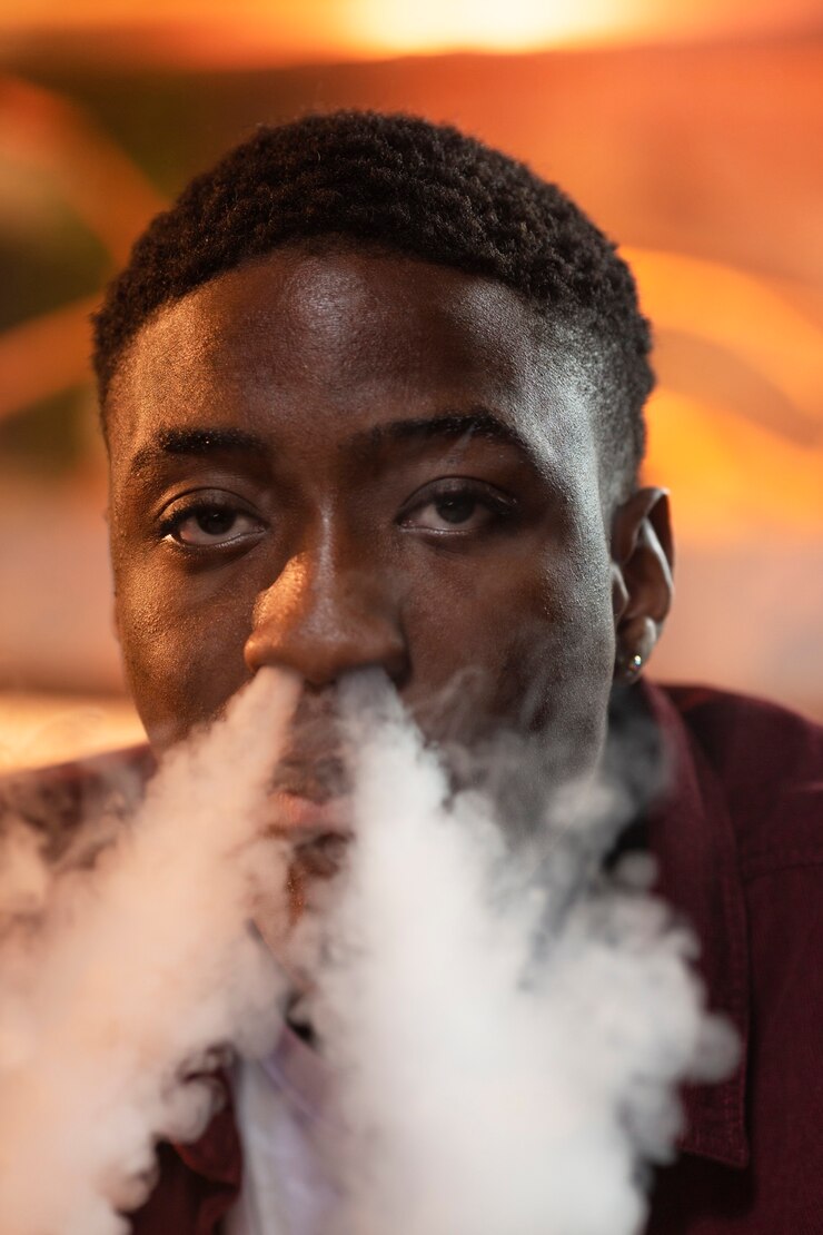 Free Photo young man vaping from a hookah in a bar
