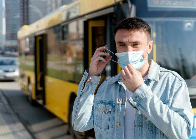 市バスを待っている若い男